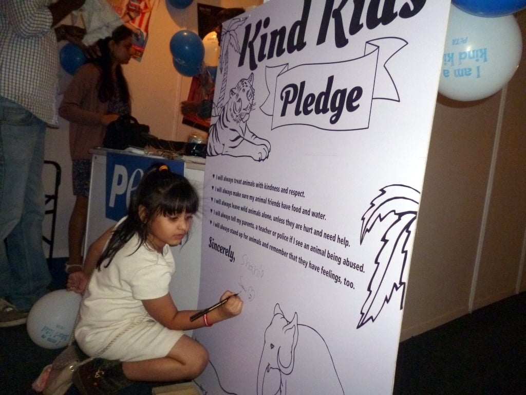 Kids signing the petition at PETA stall in IKFW